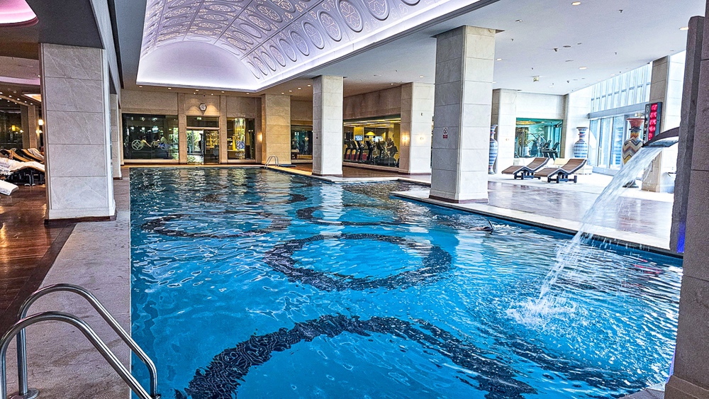 Grande piscine du spa du JW Marriott Hotel Ankara sous un plafond voûté avec éclairage violet et fontaines