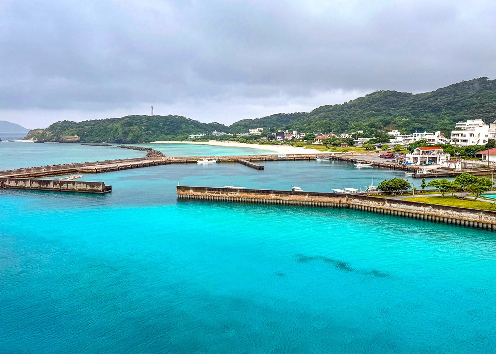 Aerial view of Kerama Port with its pontoons and crystalline turquoise waters surrounded by green hills