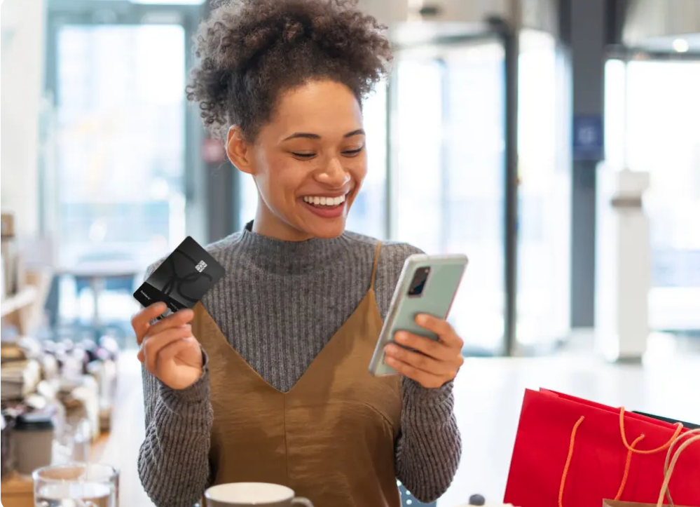 PC Financial credit cards - woman with phone and card