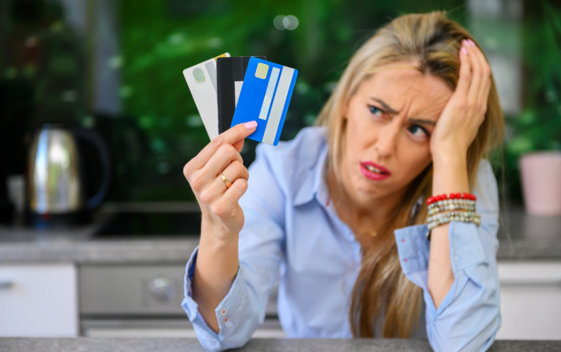 Visa Infinite vs Visa Infinite Privilege - woman looking confused with credit cards in hand
