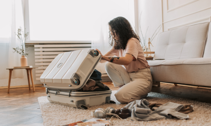 WestJet Baggage Dimensions - person packing suitcase in living room