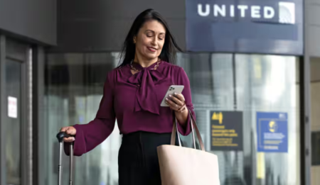 woman on phone with United Airlines signage on back ground