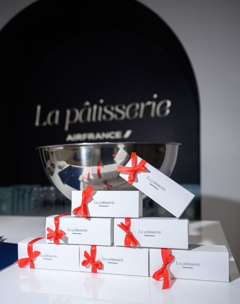 Élégantes boîtes cadeaux avec rubans rouges de La pâtisserie Air France à Toronto, présentées sous l'enseigne