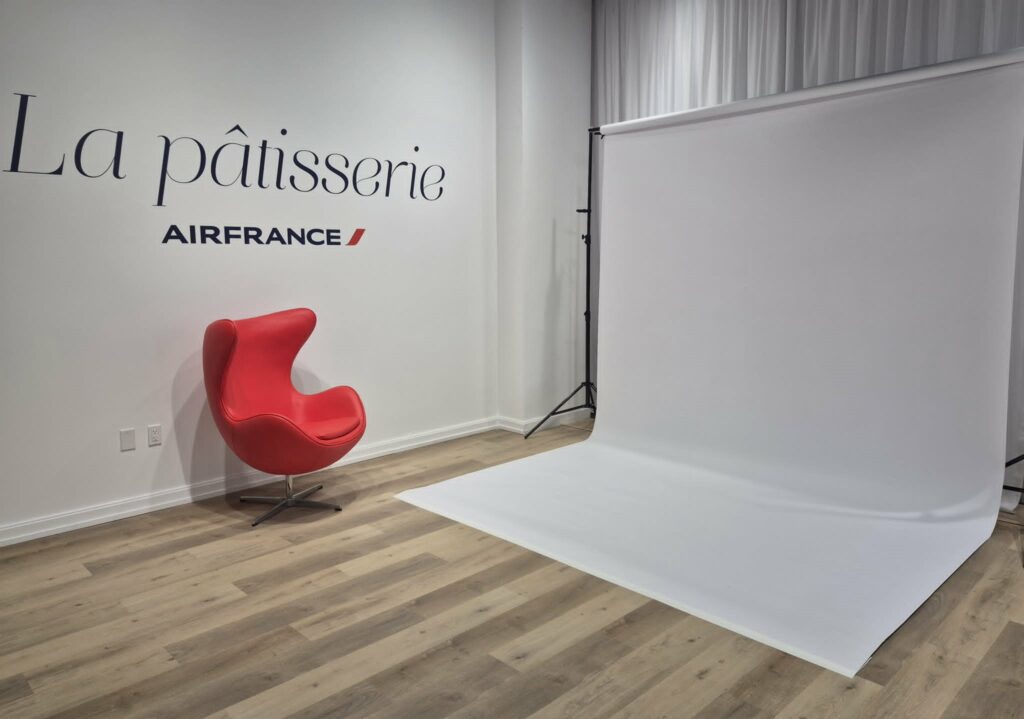 Studio de création épuré avec fauteuil rouge design et éclairage professionnel à La pâtisserie Air France à Toronto