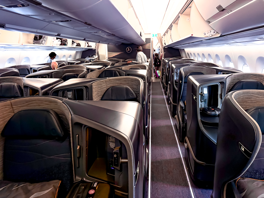 Vue couloir central cabine classe affaires Turkish Airlines A350 avec rangees de sieges premium et eclairage ambiance