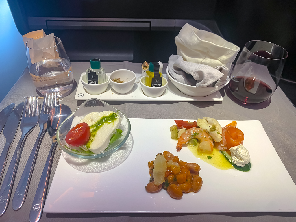 Service hors-d'oeuvre de Turkish Airlines en classe business avec amuse-bouches et vin rouge servis sur plateau élégant