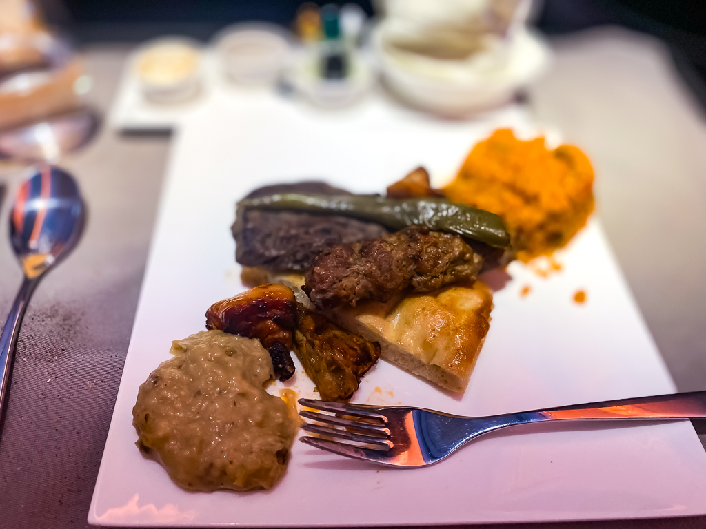 Plat principal Turkish Airlines classe affaires avec viande grillée, légumes et purée dans une présentation gastronomique