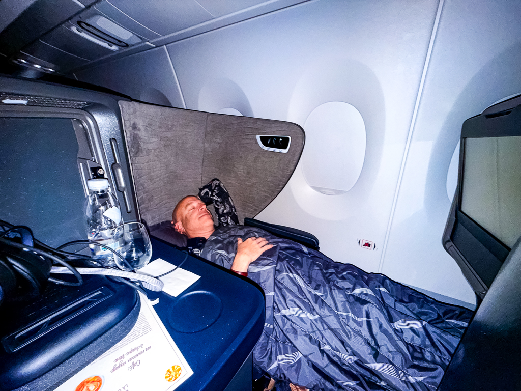 Passager Turkish Airlines se reposant en position allongée dans son siège classe affaires A350 près du hublot