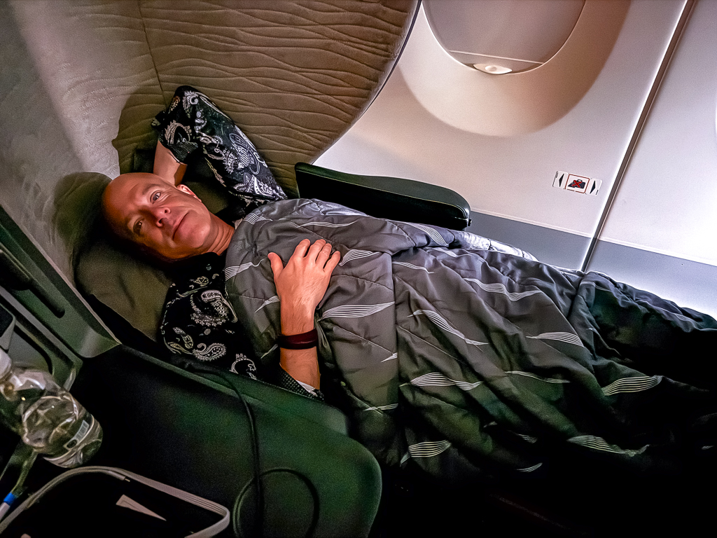 Passager Turkish Airlines installé confortablement en classe affaires A350 avec couverture et oreiller de qualité