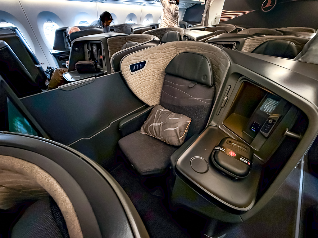 Vue panoramique de la cabine classe affaires Turkish Airlines A350 avec sieges lie-flat et design moderne beige