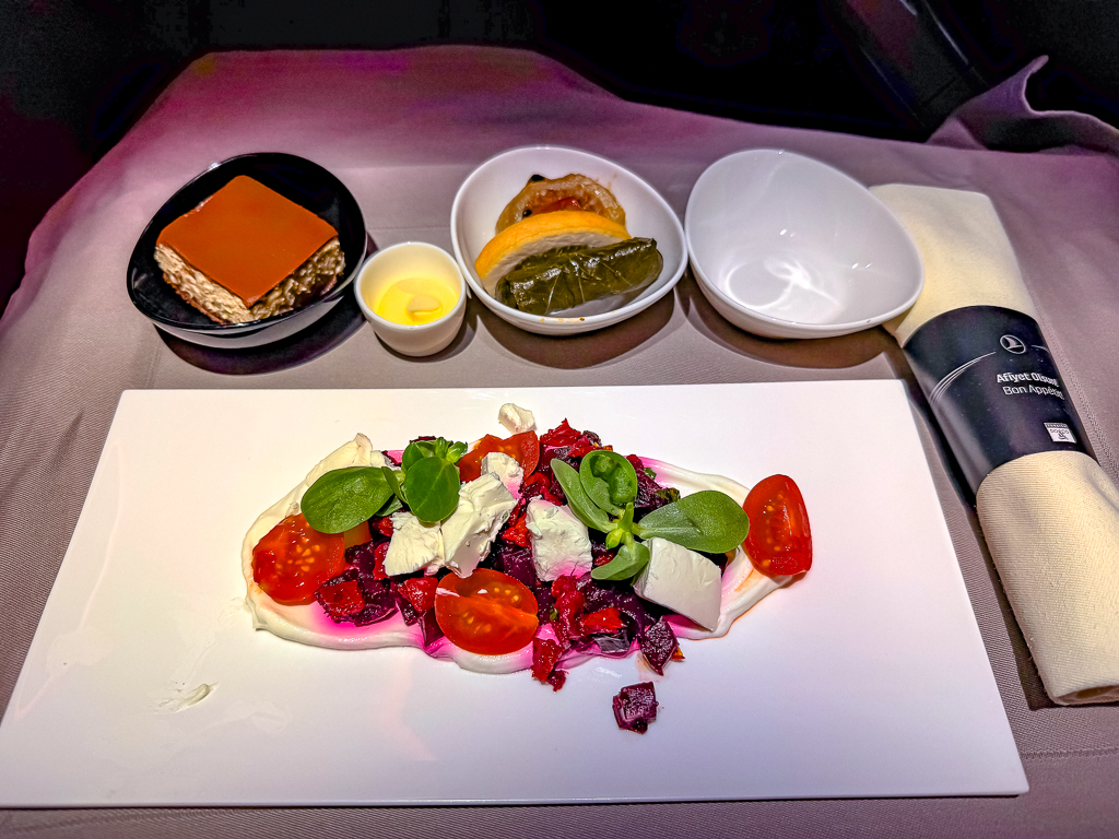 Salade Turkish Airlines classe affaires avec fromage, tomates cerises et accompagnements dans une présentation soignée