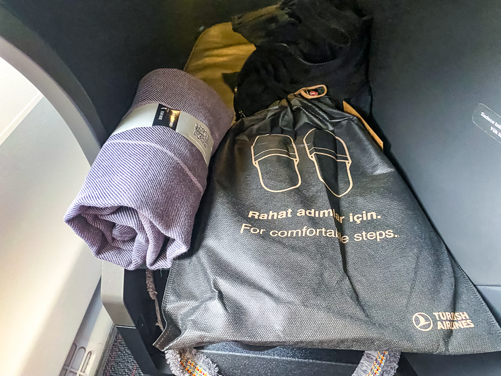 Amenities Turkish Airlines en classe affaires avec pantoufles, produits de confort et trousse de voyage sur siege A350