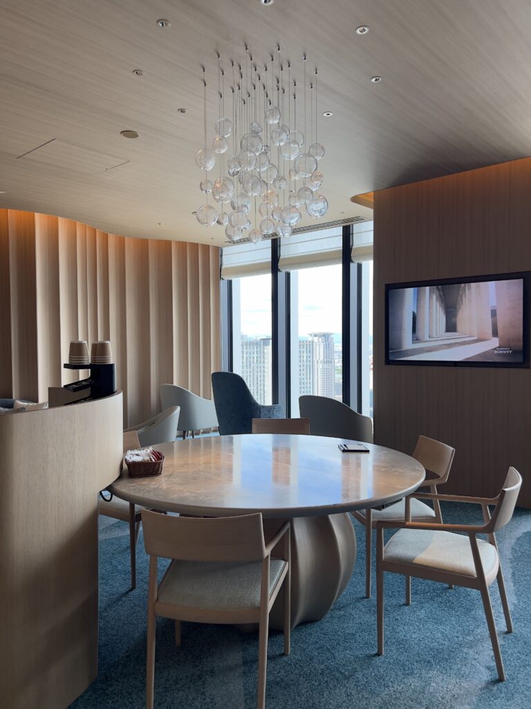 Espace détente du Autograph Osaka avec fauteuils design et vue panoramique sur les buildings et infrastructures urbaines
