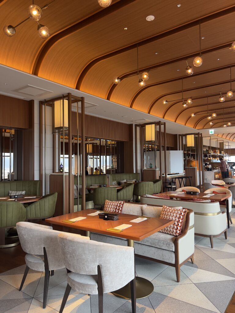 Lounge du Autograph Osaka avec fauteuils confortables et vue panoramique sur les gratte-ciels et gare d'Osaka