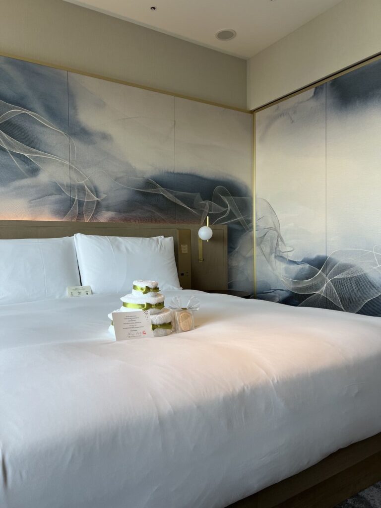 Lit king-size au Autograph Osaka avec tête de lit artistique aux motifs fumés bleus et blancs contemporains