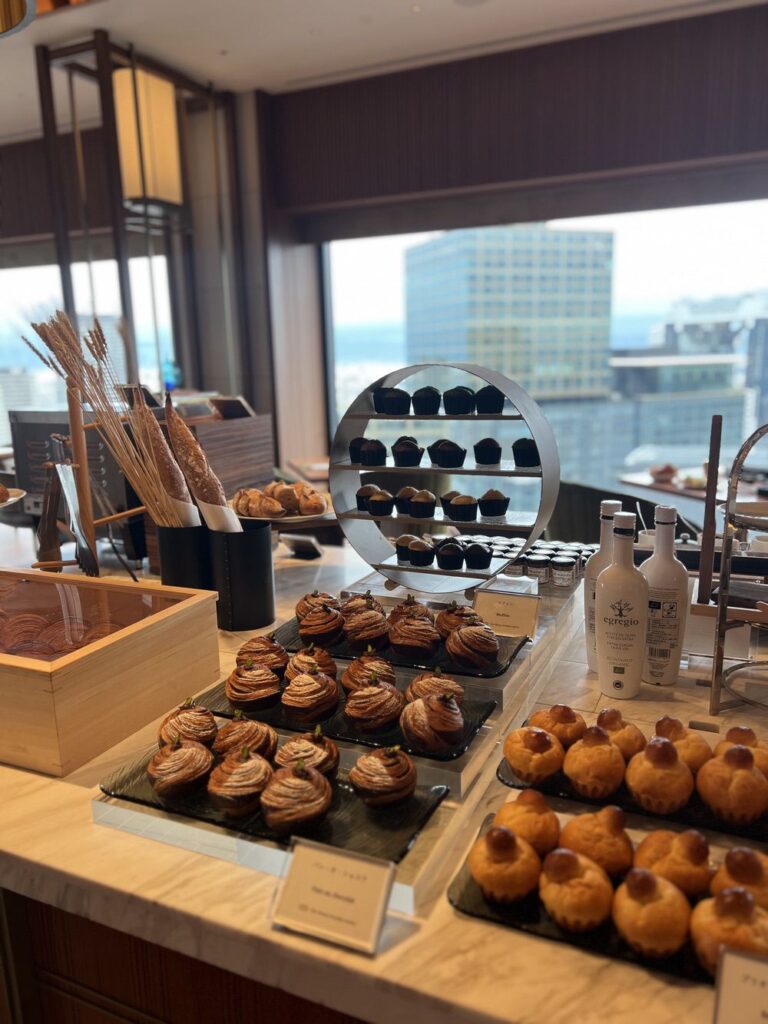 Buffet de pâtisseries de l'Autograph Osaka avec viennoiseries et vue sur la ville d'Osaka