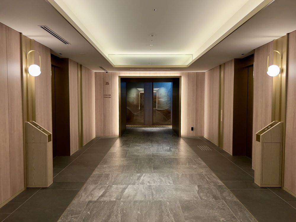 Couloir élégant menant au spa de l'Autograph Osaka avec sols en marbre et éclairage tamisé