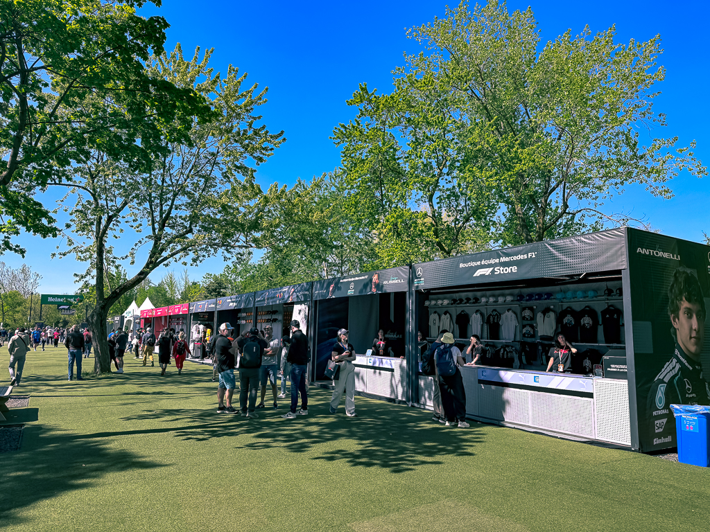 Boutiques officielles de merchandising F1 avec stands Mercedes et autres ecueries dans le paddock