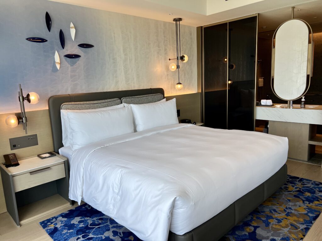 Chambre contemporaine du marriott nagasaki avec lit king-size, éclairage design et salle de bain ouverte moderne