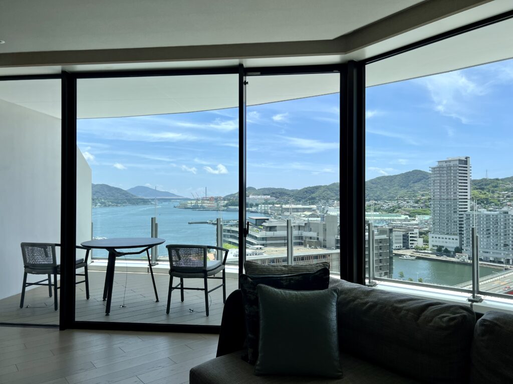 Salon spacieux d'une suite du marriott nagasaki avec canapé confortable et vue panoramique sur le port de Nagasaki