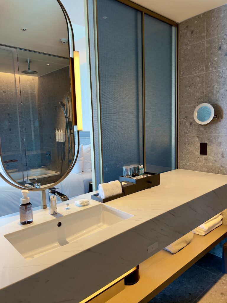 Salle de bain moderne avec baignoire et douche vitrée dans une suite du marriott nagasaki avec vue panoramique