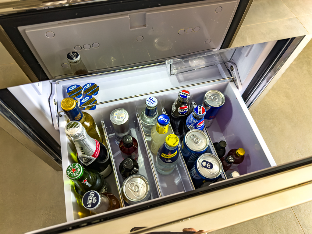 Minibar ouvert d'une suite du w ibiza montrant boissons, bières et spiritueux dans un réfrigérateur moderne