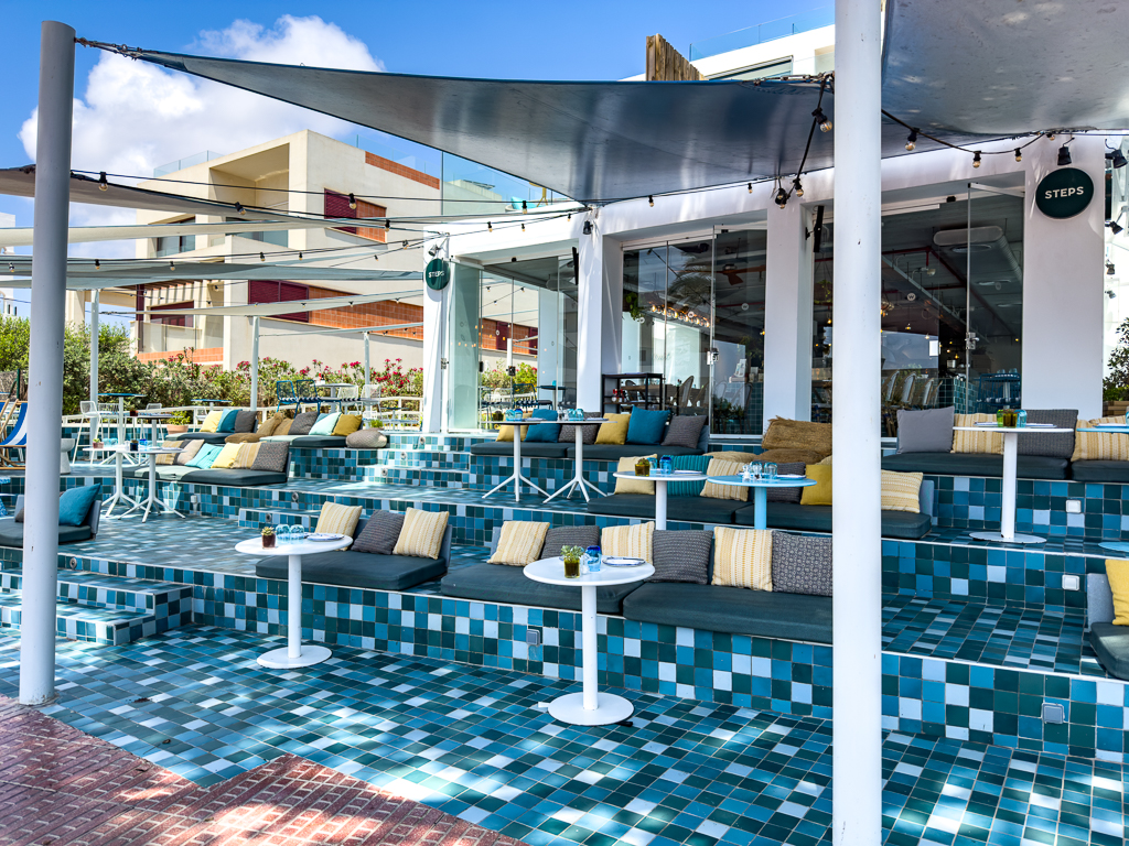 Terrasse du w ibiza avec piscine carrelée bleue et salons sous voiles d'ombrage face à la mer Méditerranée