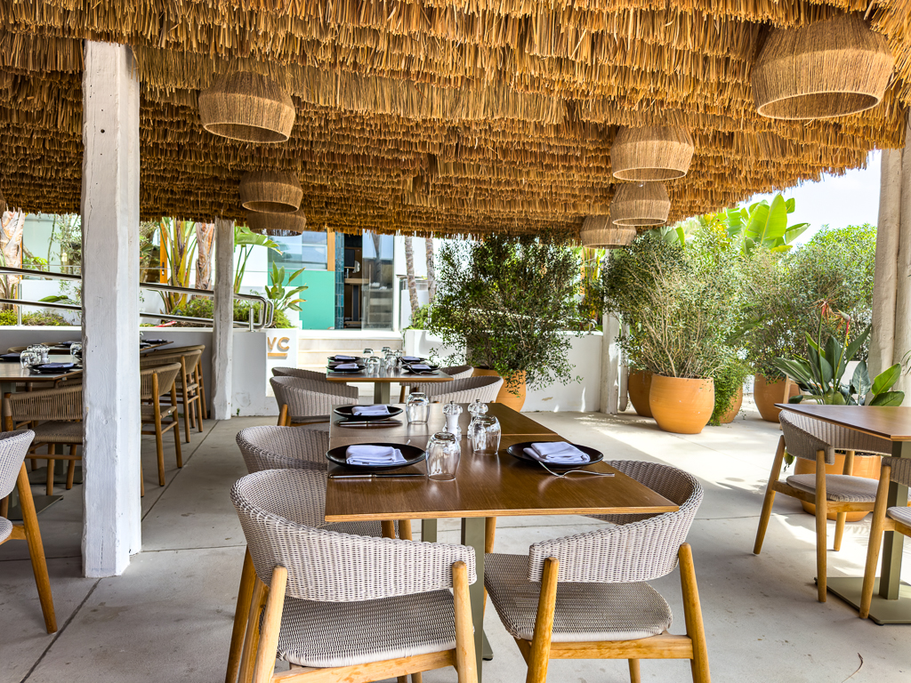 Salle du restaurant Yellow Fish du w ibiza avec toit en paille, lustres naturels et tables dressees