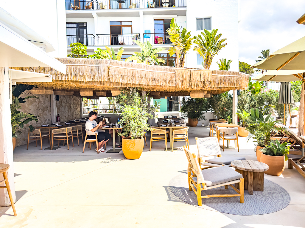 Restaurant Yellow Fish du w ibiza avec terrasse couverte, mobilier en bois et plantes mediterraneennes