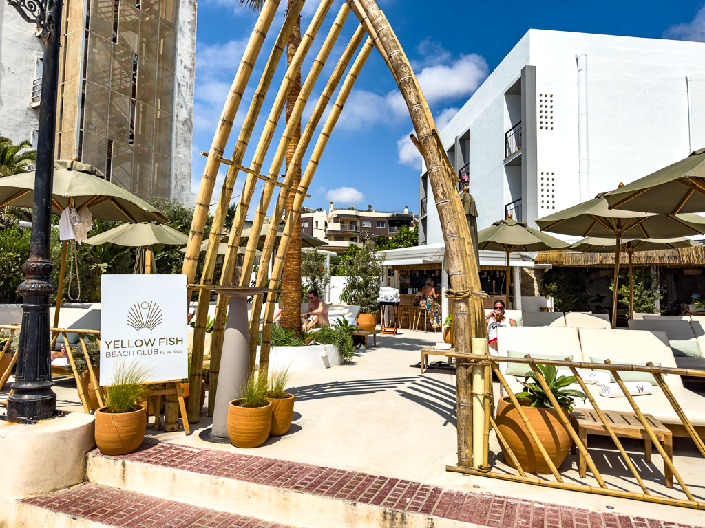 Beach club Yellow Fish du w ibiza avec structures en bambou et mobilier naturel sur la plage