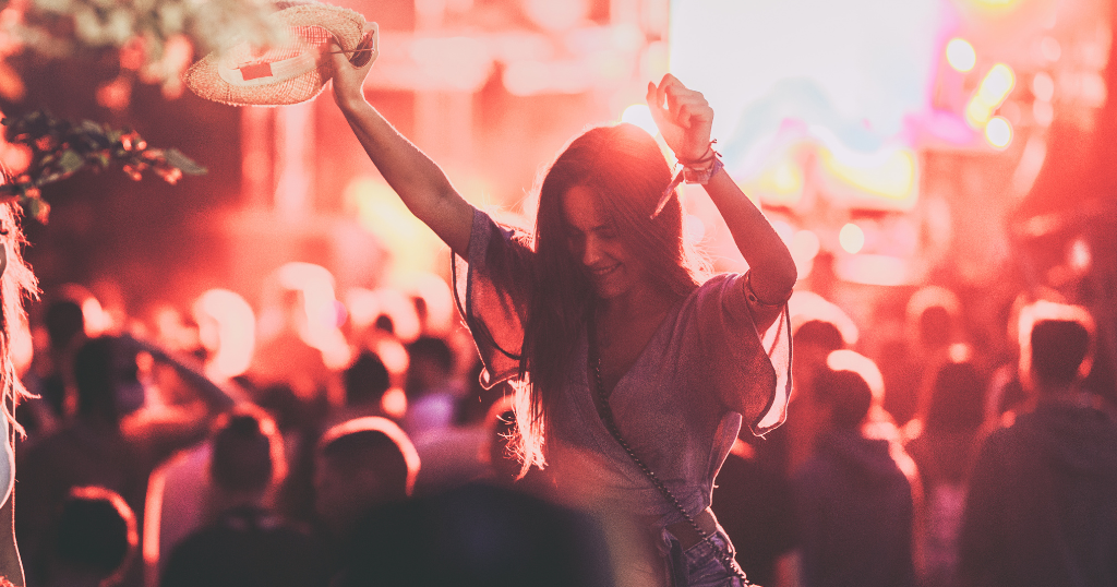 person with hands in the air at concert