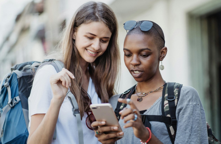 two friends wearing backpacks with phone