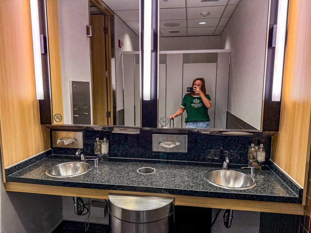 Sanitaires modernes du salon air canada équipés de double vasque en inox et miroirs avec éclairage LED intégré