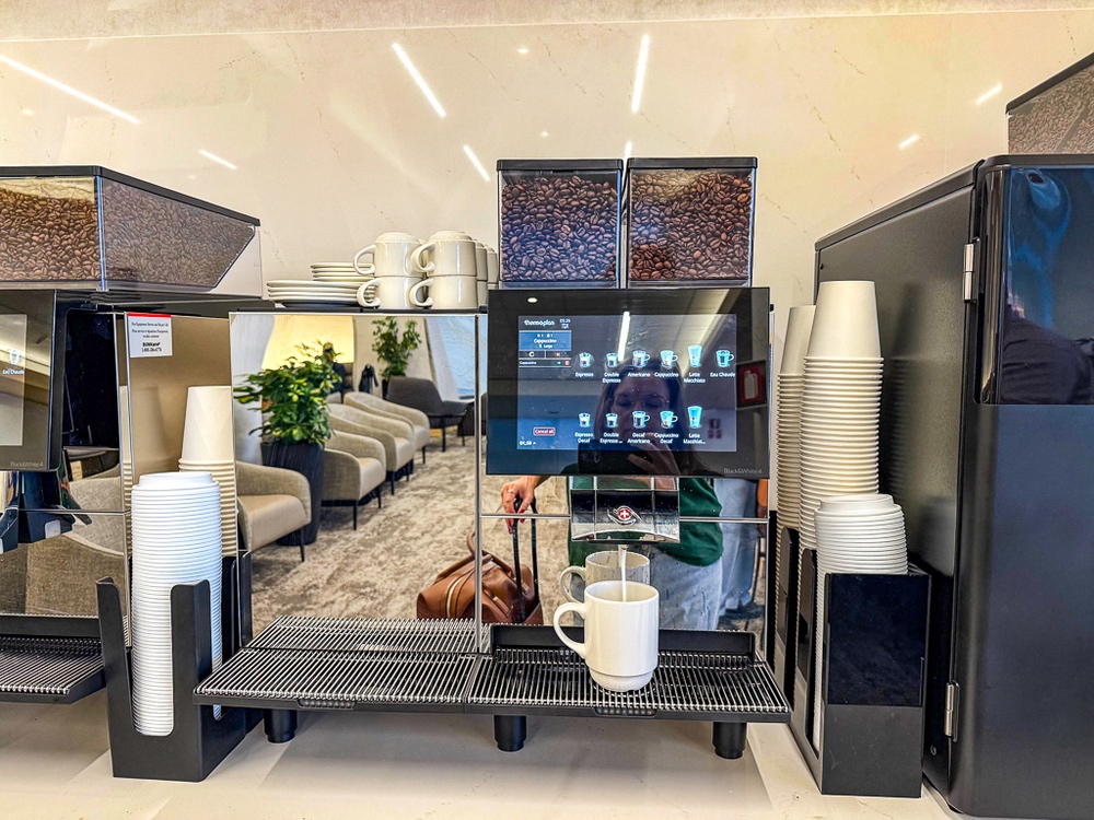 Machine à café automatique haut de gamme du salon air canada avec grains visibles et sélection de boissons chaudes