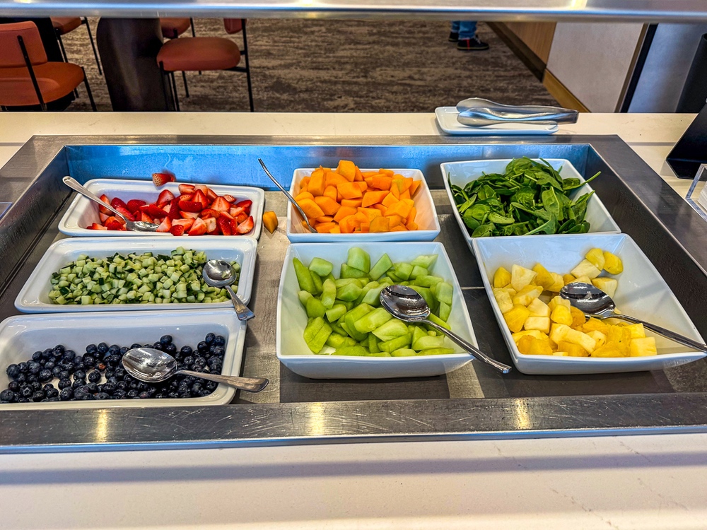 Sélection de fruits et légumes frais du salon air canada avec melons, épinards, concombres présentés en buffet libre-service