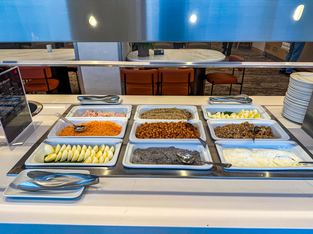 Buffet d'accompagnements froids du salon air canada présentant légumes, fruits et garnitures fraîches en bacs réfrigérés