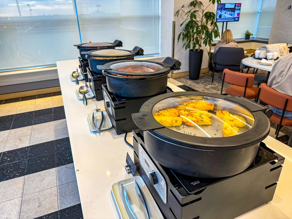 Buffet de plats chauds du salon air canada avec chafing-dishes et variété de mets cuisinés servis en libre-service