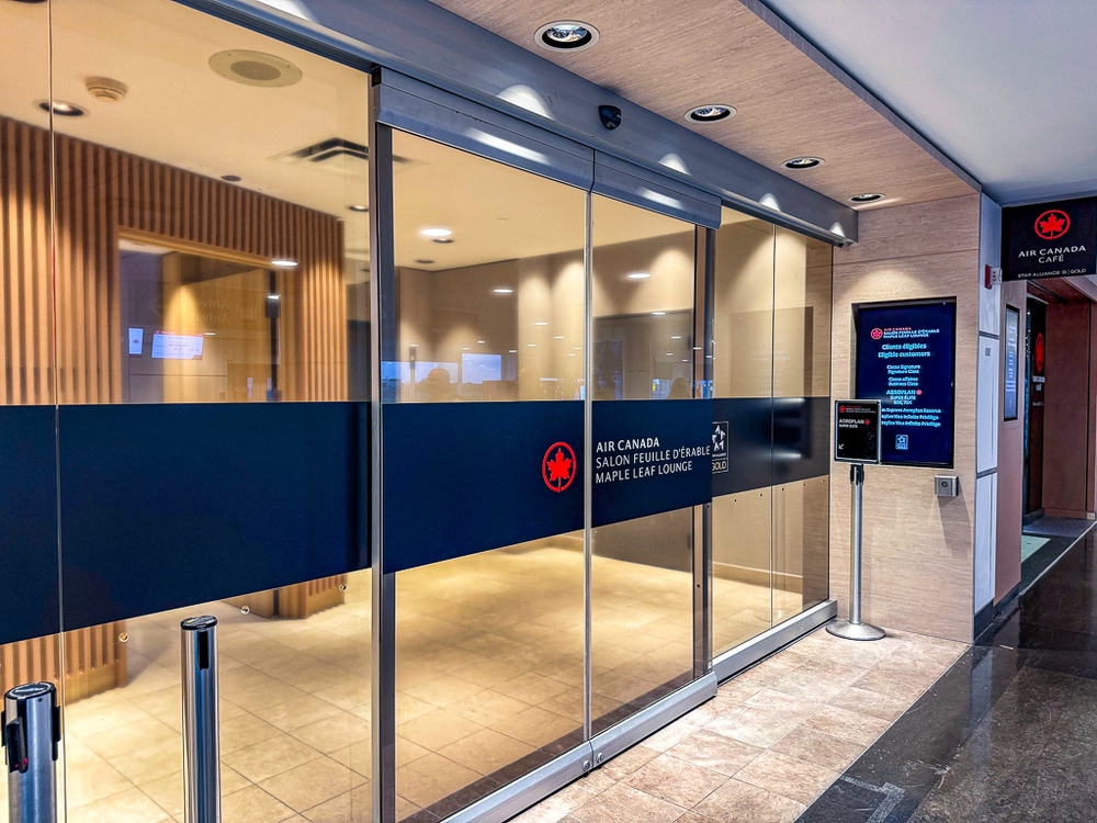 Main entrance to the air canada lounge with automatic glass doors and official signage visible