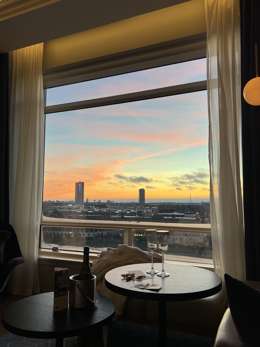 Coin salon de la chambre au coucher du soleil avec vin mousseux offert