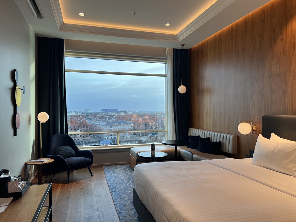 Chambre exécutive spacieuse avec mobilier moderne et grande fenêtre sur le canal