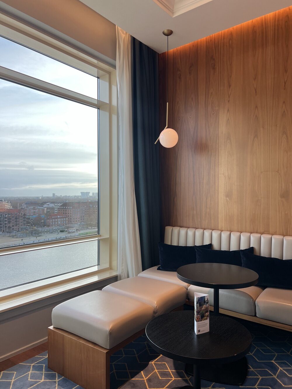 Coin salon de la chambre avec banquette et vue sur le canal
