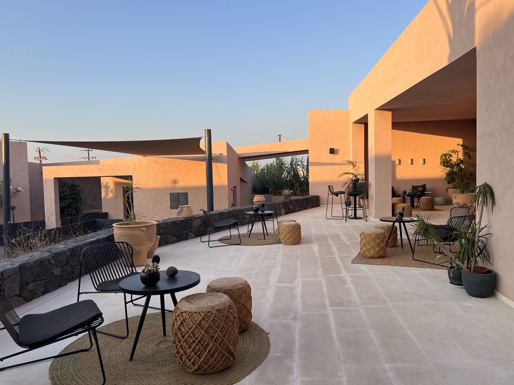 Outdoor lounge terrace at Domes Novos Santorini at sunset