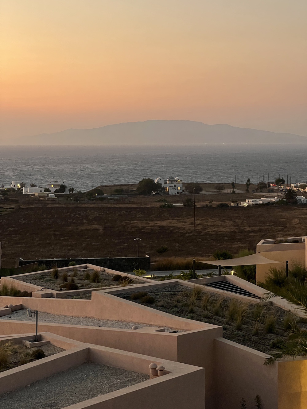 Sunset over the Aegean Sea and a Santorini village