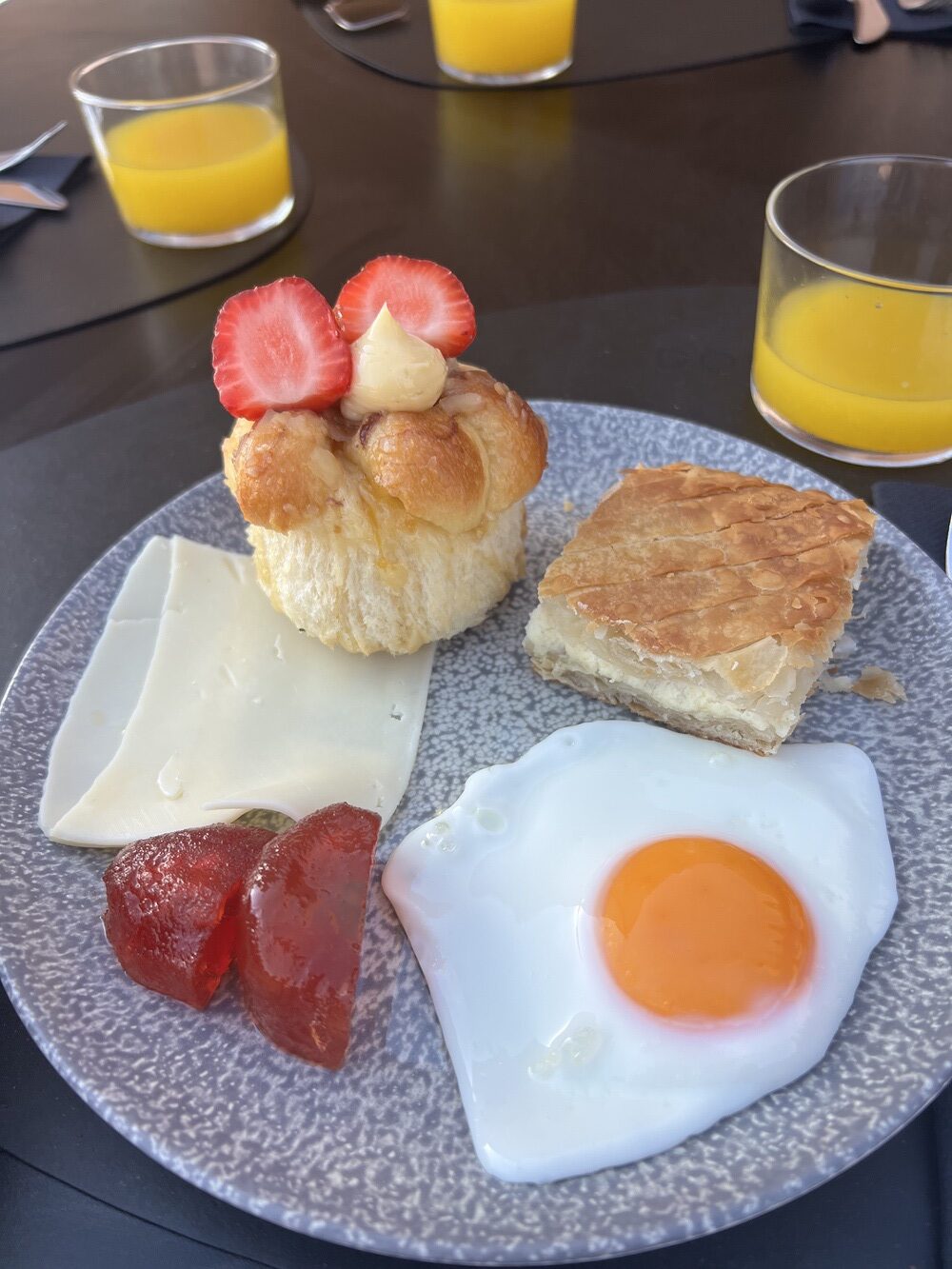 Breakfast plate with egg, brioche, and orange juice