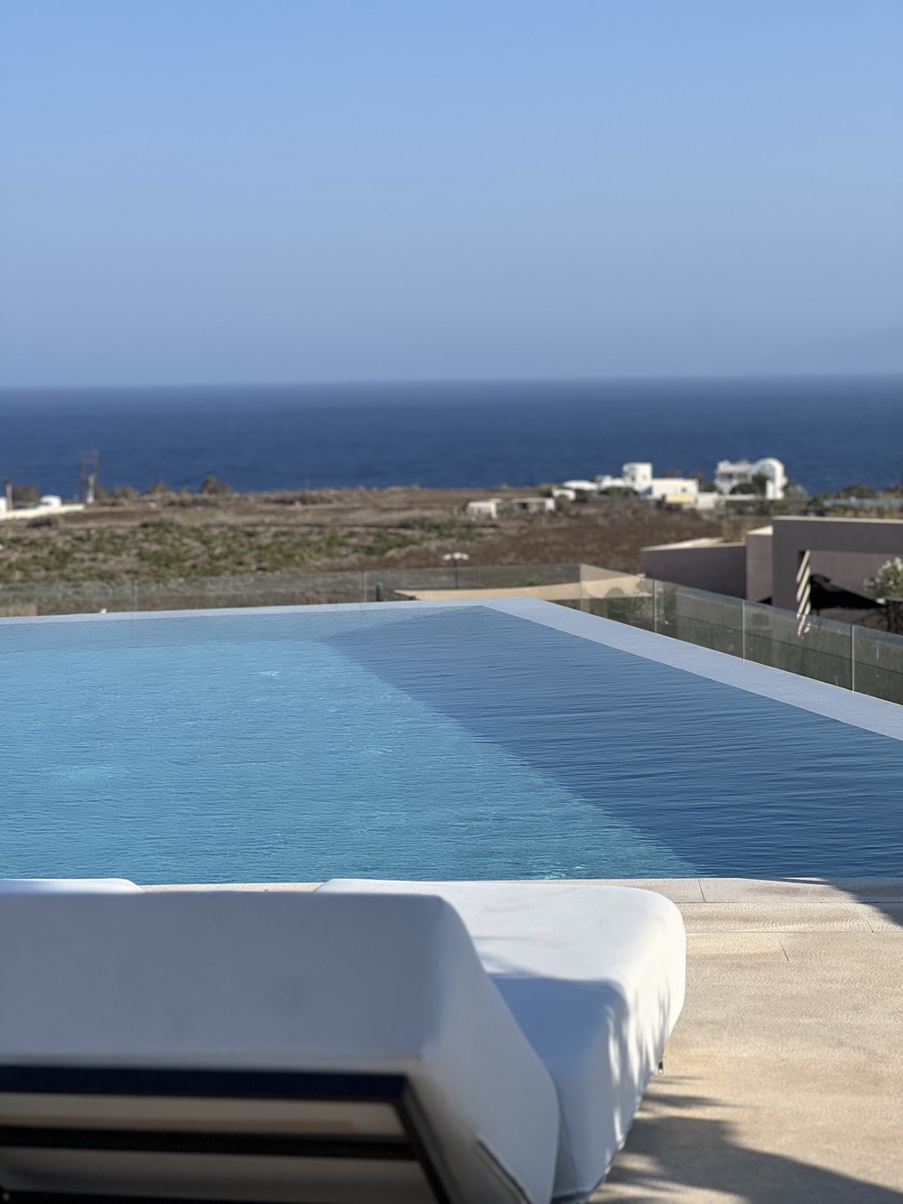 Private pool and lounge chair with view of the Aegean Sea