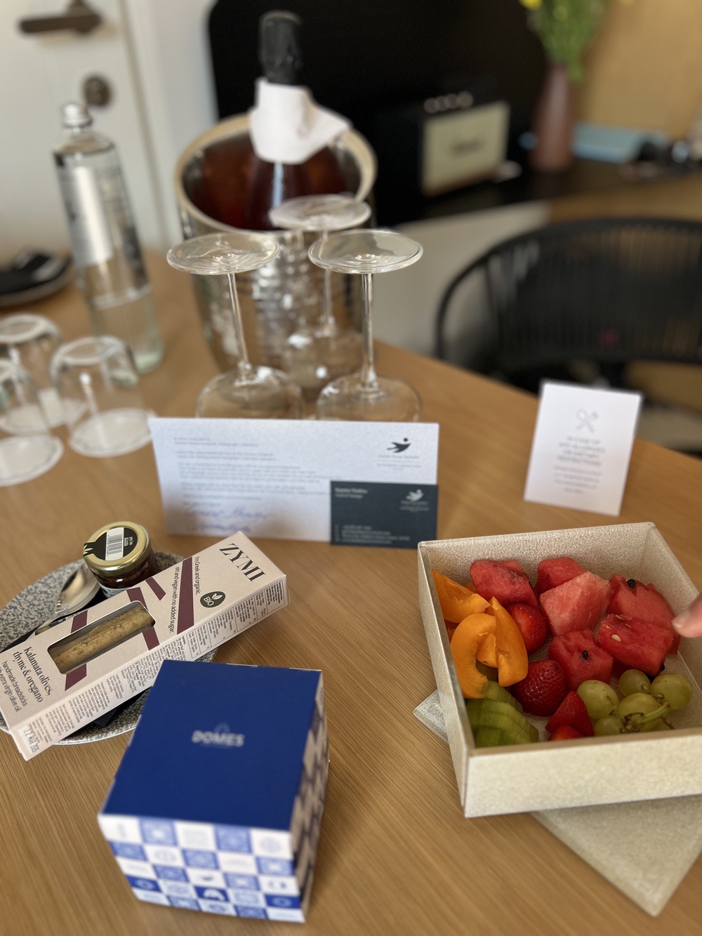 Welcome gift and fruit platter in room at Domes Novos Santorini