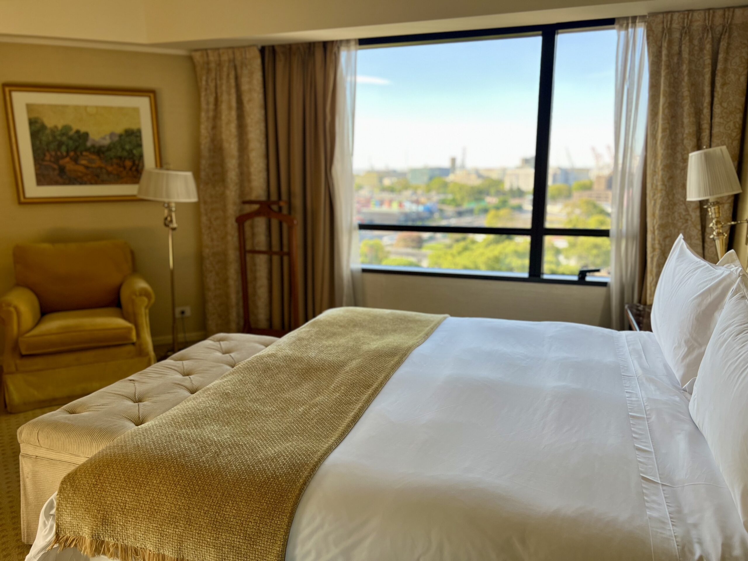 Chambre de la suite avec lit King, fauteuil et vue sur la ville