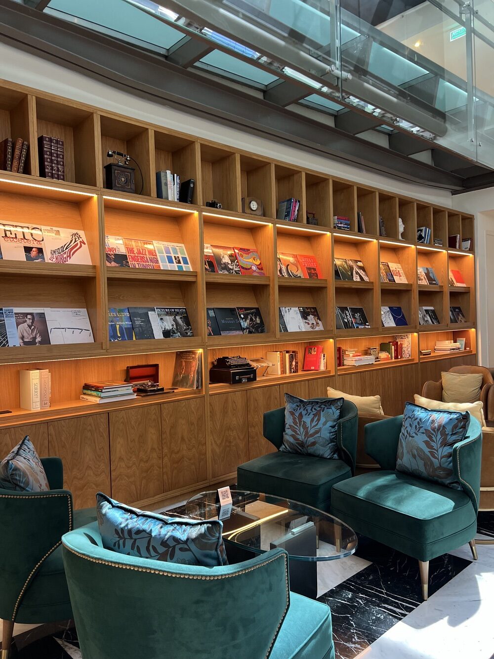 Lounge-library with green velvet armchairs at the Recoleta Grand