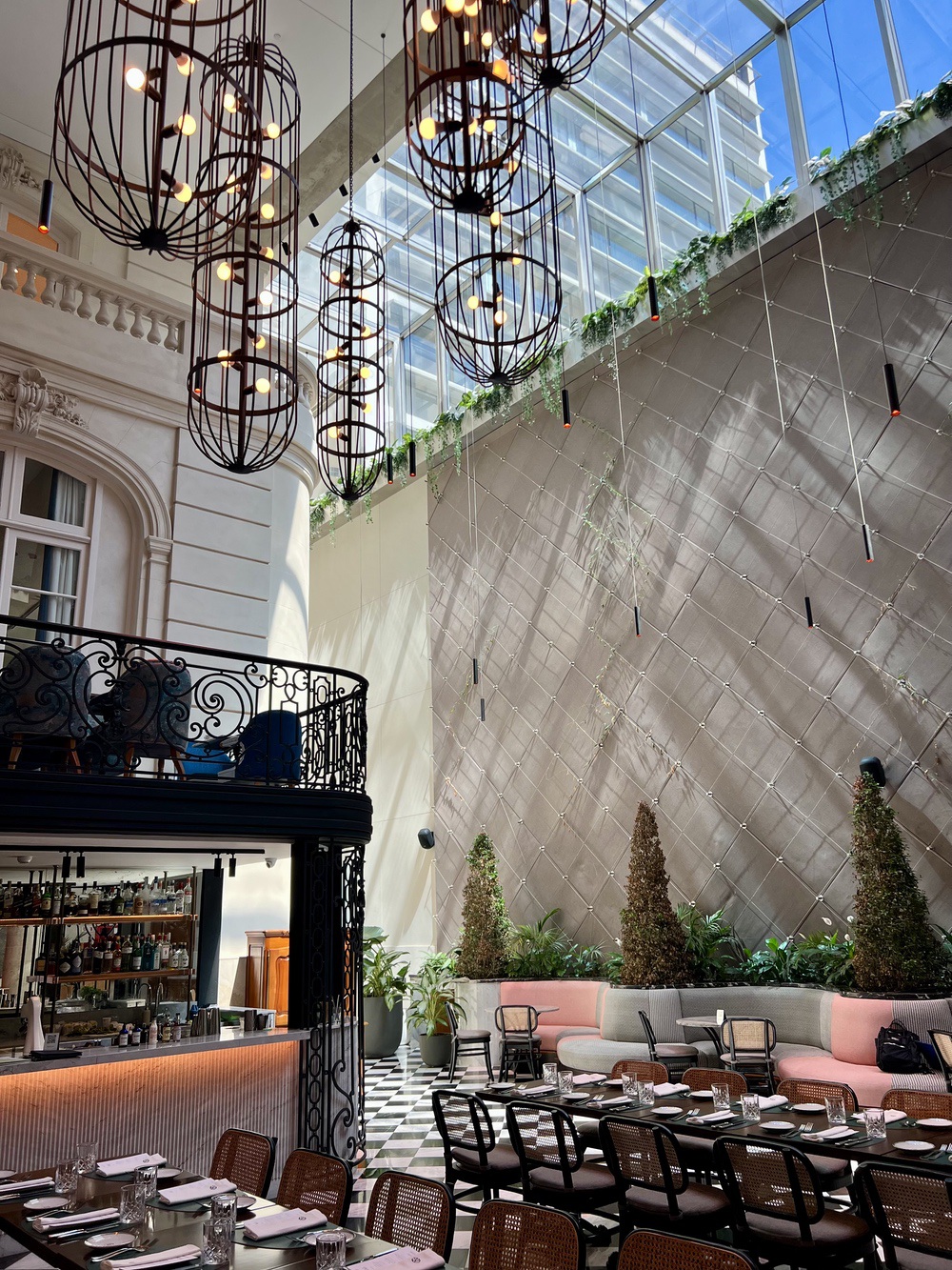 The Atrium restaurant under glass roof, chandeliers and checkered floor