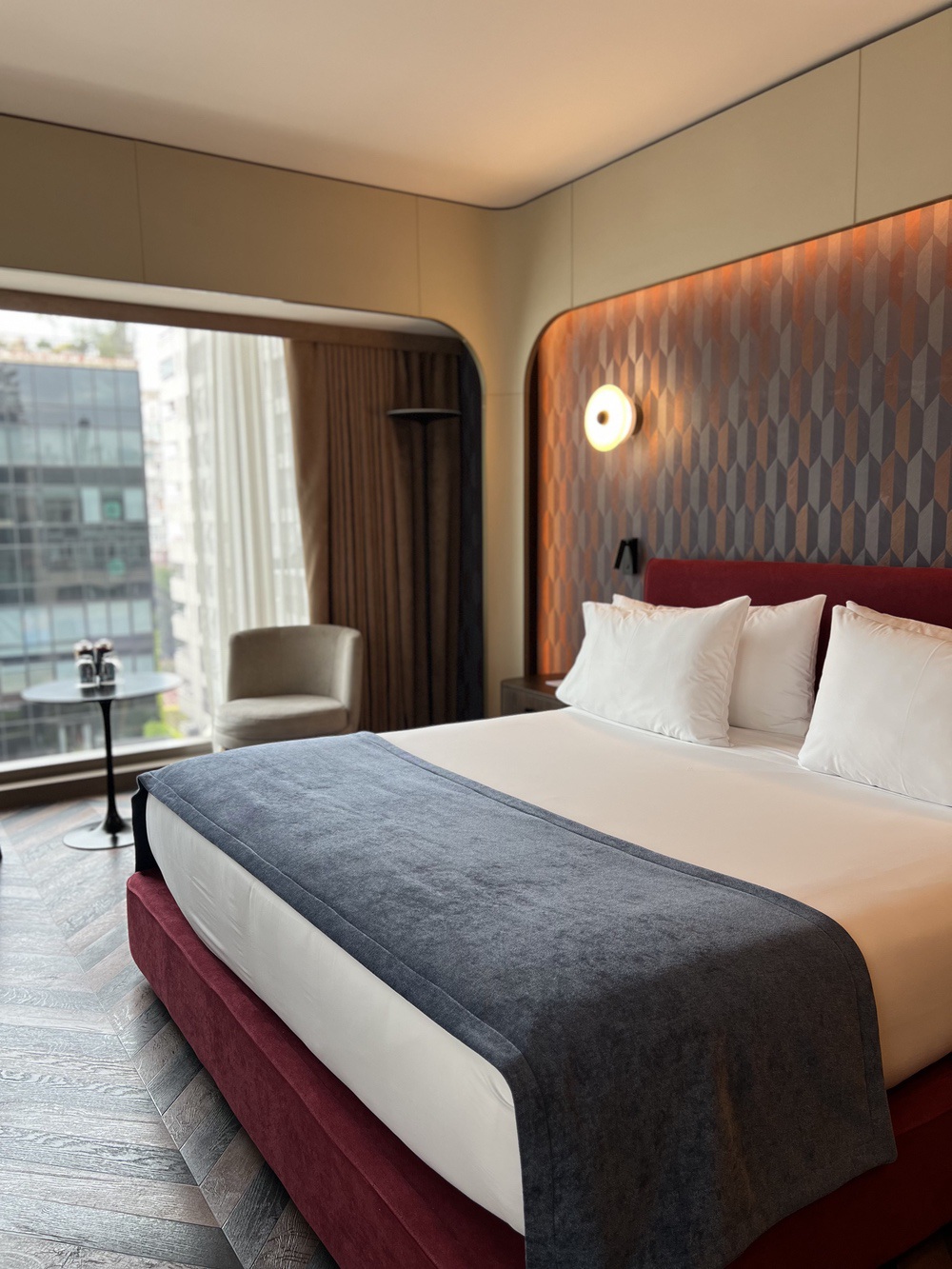 Executive room with patterned headboard and city view